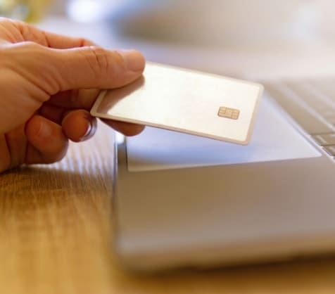 Credit card held over a laptop